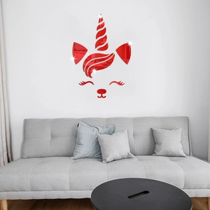 Close-up of red acrylic mirror unicorn wall sticker on a white wall above a modern sofa
