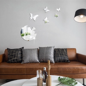 Detailed view of silver acrylic butterfly mirror wall stickers set on a modern grey wall