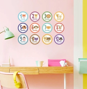 Detail of 12 animal milestone wall stickers for baby room growth tracking in pink decor