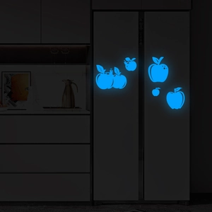 Luminous blue apple and caterpillar wall stickers glowing on a dark refrigerator