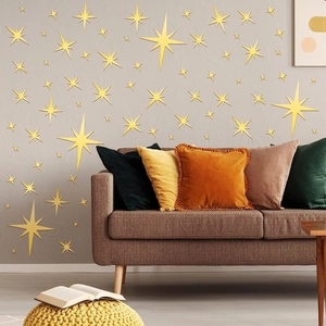Detailed view of various sizes of golden star wall stickers on a grey living room wall
