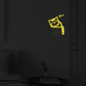 Luminous sleeping cat wall sticker glowing in yellow neon light above a light switch detail