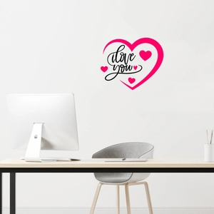 Close-up of pink heart wall sticker with I love you text on white wall above office desk