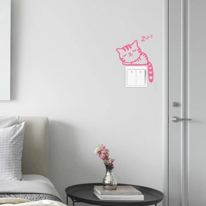 Detail of pink sleeping cartoon cat glow wall sticker with Zzz symbols near a light switch