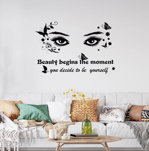 Black PVC eye wall decal with butterfly and beauty quote above a modern sofa décor