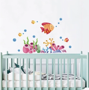 Vibrant ocean life wall decals featuring tropical fish and coral over a nursery crib