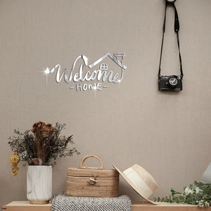 Macro detail of Welcome Home mirror wall sticker with artistic font on a textured wall