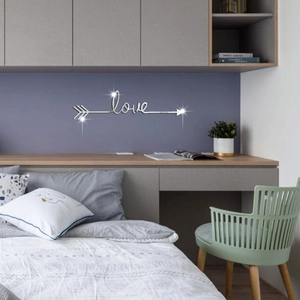 Macro detail of silver acrylic LOVE mirror wall sticker with arrow design on bedroom wall