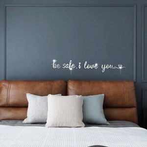 Macro detail of 'be safe, i love you' mirror acrylic wall decal on a blue bedroom wall