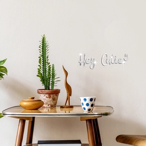 Macro detail of silver acrylic mirror wall decal with Hey Cutie lettering and smiley face