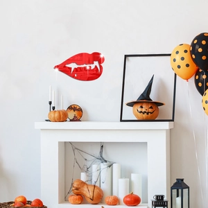 Close-up of red acrylic vampire lip mirror wall sticker on a white wall for Halloween decor