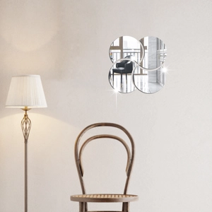 Close-up of interlocking circular mirror wall stickers in a minimalist living room setting