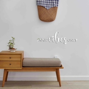 Detail of 3D acrylic mirror wall sticker featuring GOOD vibes ONLY in a modern living room