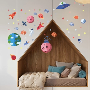 Space themed glow in the dark wall decals with rockets and planets in a kids bedroom