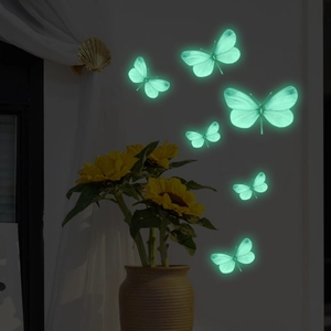 Detailed view of luminous butterfly wall stickers glowing in a dark bedroom setting