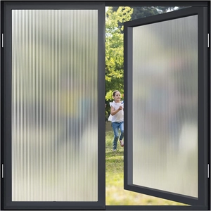 Vertical fluted glass film on black frame showing privacy frosting and soft outdoor view