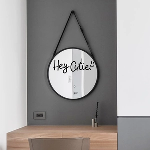Modern black round mirror with Hey Cutie wall sticker and hanging strap decor