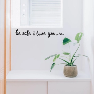 Black cursive wall decal reading be safe i love you with heart motif on white wall