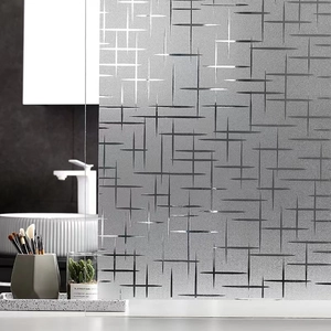 Detail view of frosted window privacy film with silver cross pattern in a modern bathroom