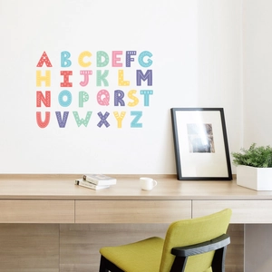 Gros plan de 26 stickers muraux de l'alphabet colorés sur un mur blanc propre