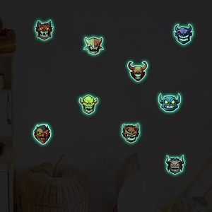 Glow-in-the-dark Halloween monster stickers shining on a child room wall at night