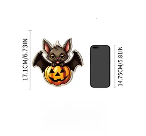 Detail view of a Halloween bat and pumpkin wooden pendant with size comparison to a smartphone