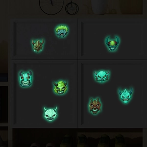 Luminous Halloween monster stickers glowing green on a dark grey drawer cabinet set