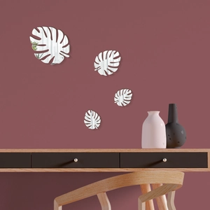 Detail of four-piece silver monstera leaf acrylic mirror wall stickers on a pink wall
