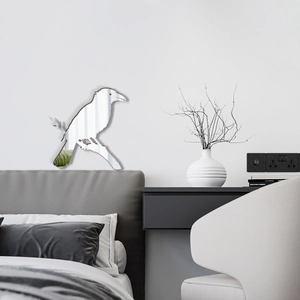 Macro shot of a silver acrylic mirror bird silhouette wall sticker above a bedroom bed