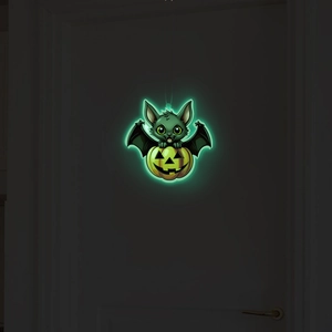 Luminous Halloween bat inside pumpkin decoration glowing against dark background