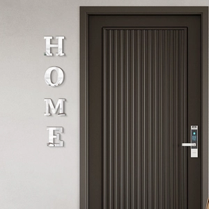 Macro detail of 3D silver acrylic mirror wall stickers spelling HOME on a white wall