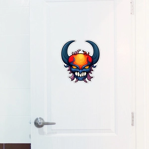 Close-up of a colorful monster decal featuring horns on a clean white wooden door