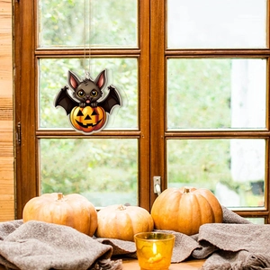 Halloween bat and pumpkin wooden hanging ornament displayed on a cozy rustic window sill