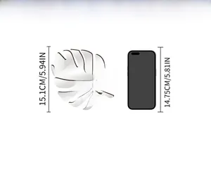Silver mirror monstera leaf wall decal with size comparison against a smartphone