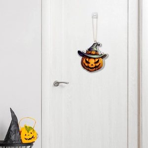 Detail of hanging Halloween pumpkin ornament with a purple wizard hat on a white door