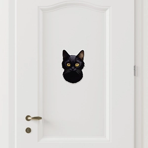 Black cat wall decal with yellow eyes for room decor on a white door backdrop