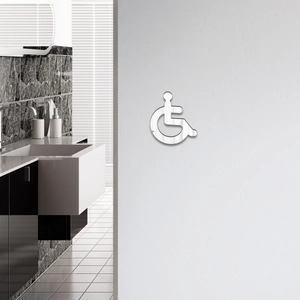 Close-up of mirror silver acrylic wheelchair symbol sticker for bathroom accessibility