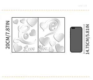 Detail view of mirror acrylic Love You wall sticker with size comparison to a smartphone