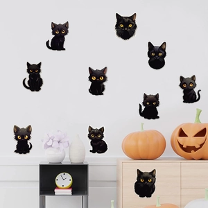 Detail van zwarte kat muurstickers met gele ogen op een wit muuroppervlak in huis