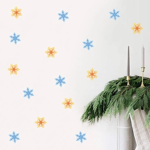 Blue and gold snowflake wall decals in a cozy Christmas home setting with a fireplace