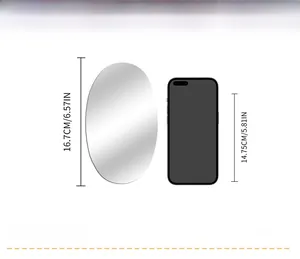 Size comparison of oval acrylic mirror wall sticker next to a mobile phone with dimensions