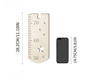 Detail view of wooden growth chart with star patterns and a smartphone for size reference