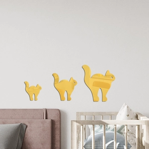 Trois stickers muraux chat en miroir acrylique doré de tailles variées sur un mur gris