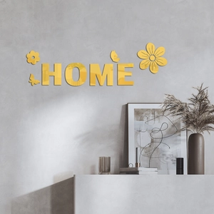 Détail de l'autocollant mural miroir doré 3D avec lettres HOME et fleurs sur mur gris