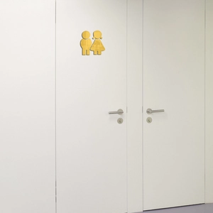 Vue détaillée des plaques de toilette en acrylique doré avec silhouettes homme et femme