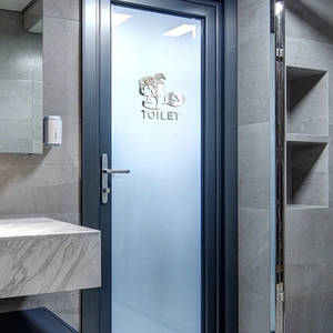 Mirror acrylic toilet sign featuring a cartoon figure and TOILET text on a glass door