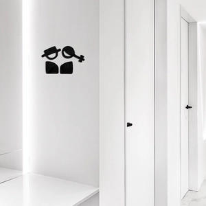 Minimalist black acrylic restroom signage with abstract male and female symbols on a white wall