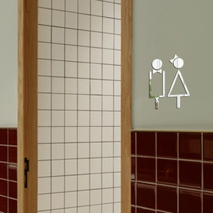 Detailed view of silver 3D acrylic mirror restroom sign on a tiled bathroom wall