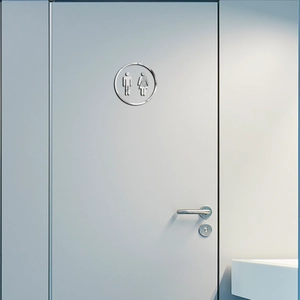 Silver mirror acrylic round restroom sign with male and female icons on a modern door