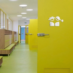 Modern 1mm mirror acrylic toilet sign sticker on a yellow door in a public hallway